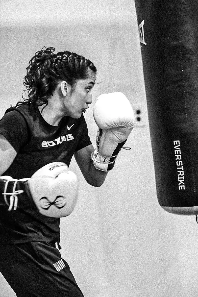 Motion shot of Alyssa Mendoza as she attacks her punching bag during training.