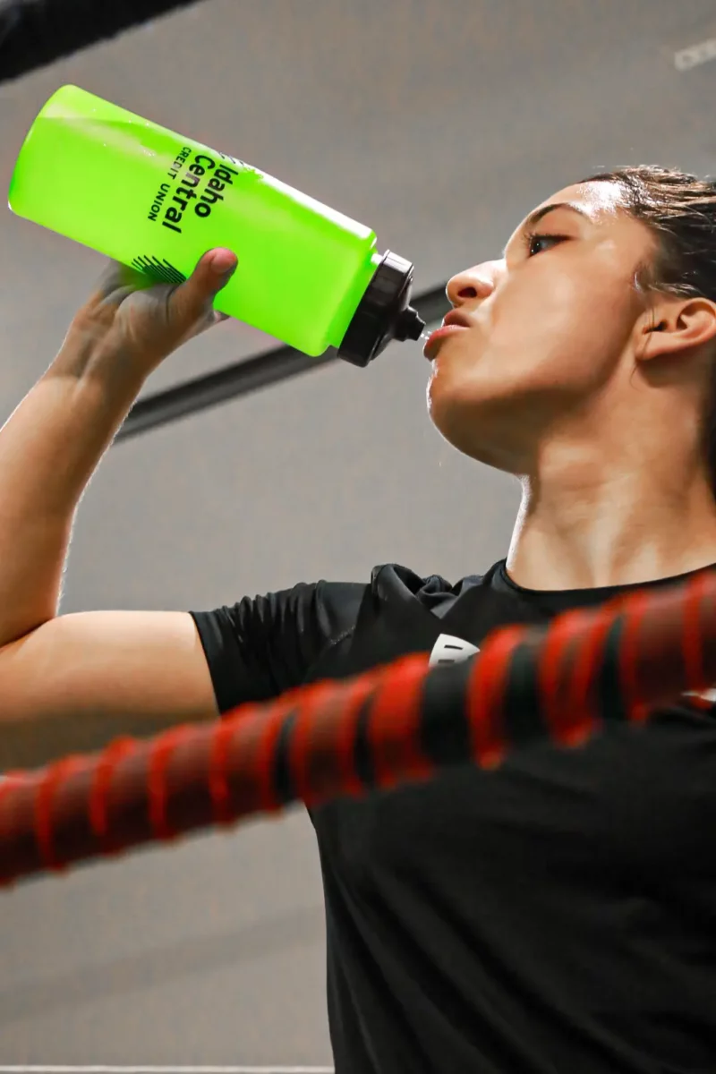 Boxing champion Alyssa drinks from a green ICCU water bottle.