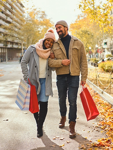 A couple walking together while holding shopping bags