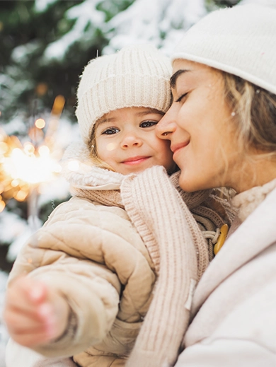 A child with a sparkler held by her mother